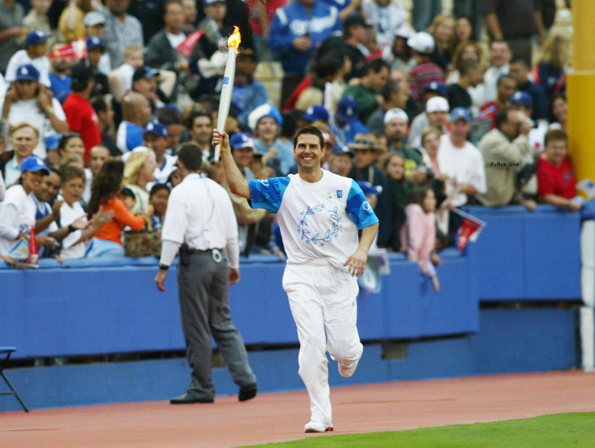 Tom Cruise carries the Olympic Flame around Dodger Stadium in 2004