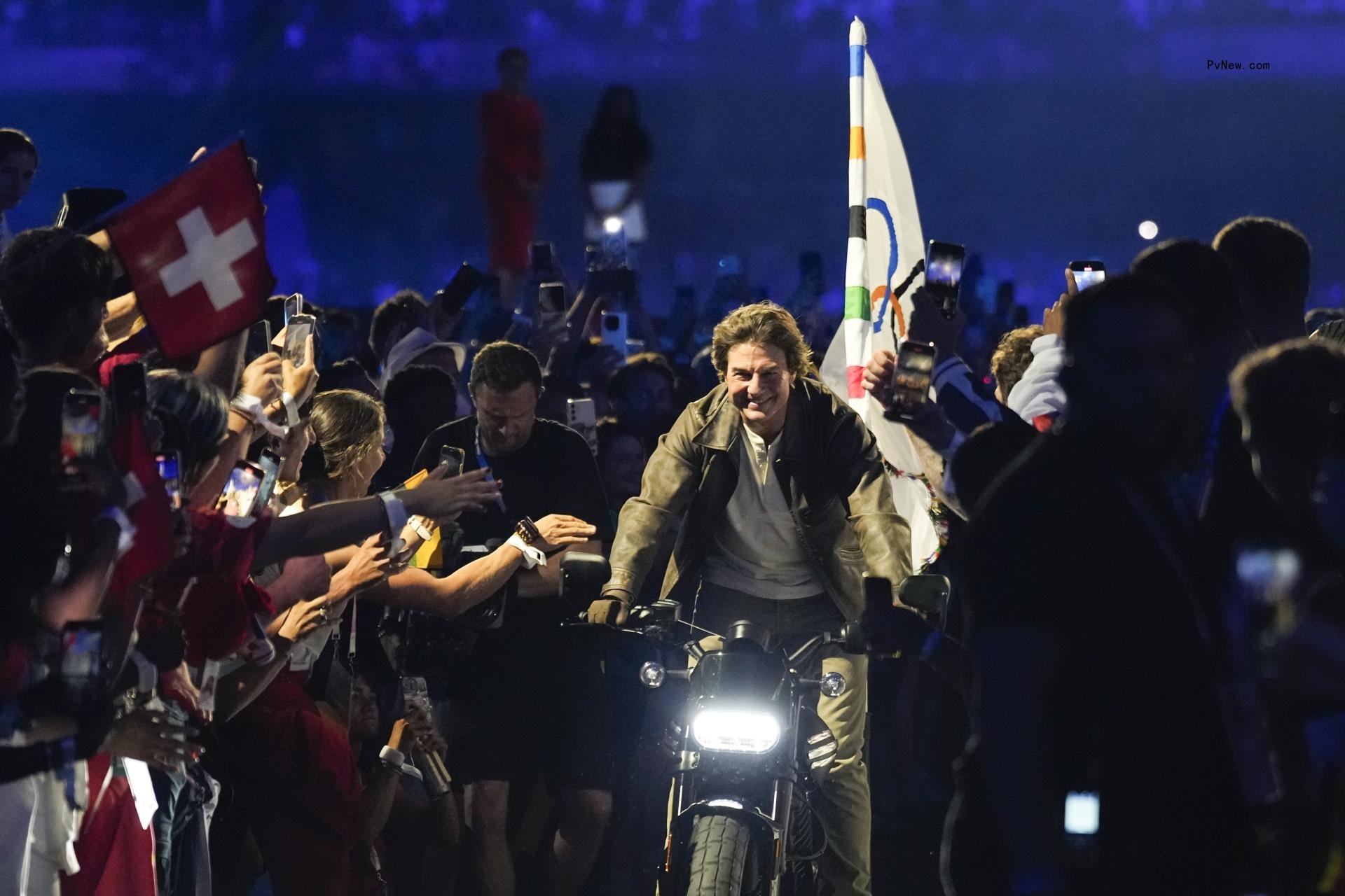 Tom Cruise rides a motorbike with the Olympic flag attached during the 2024 Summer Olympics closing ceremony at the Stade de France