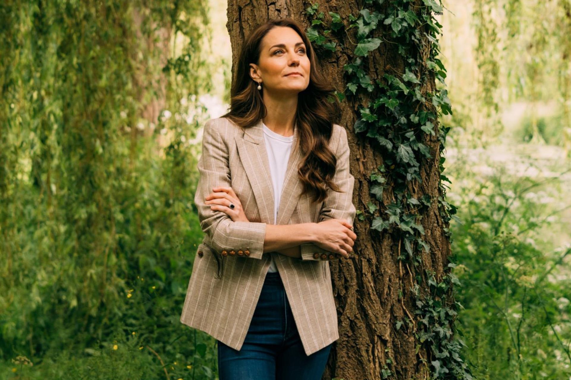 Kate Middleton poses in front of a tree.