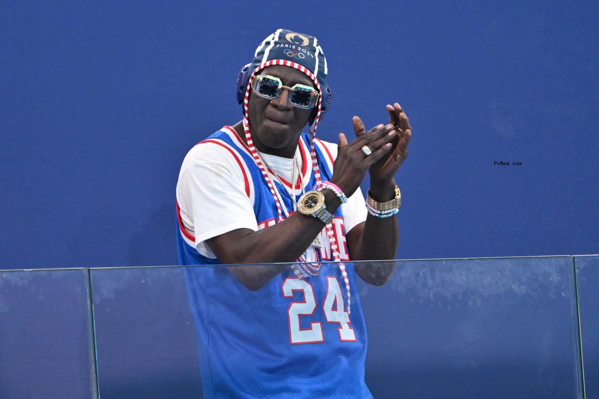 US actor and rapper William Jo<i></i>nathan Drayton Jr. known by his stage name Flavor Flav, gestures before the women's water polo preliminary round group B match between Italy and USA during the Paris 2024 Olympic Games at the Aquatics Centre in Saint-Denis, north of Paris, on July 31, 2024. 