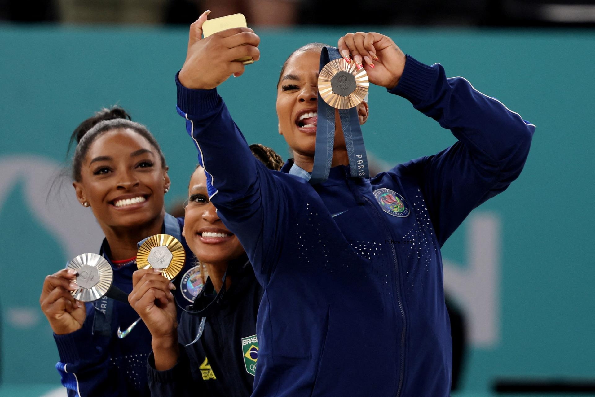 Gold medallist Rebeca Andrade of Brazil celebrates on the podium with silver medallist Simone Biles of United States and bro<i></i>nze medallist Jordan Chiles of United States on Aug. 5.