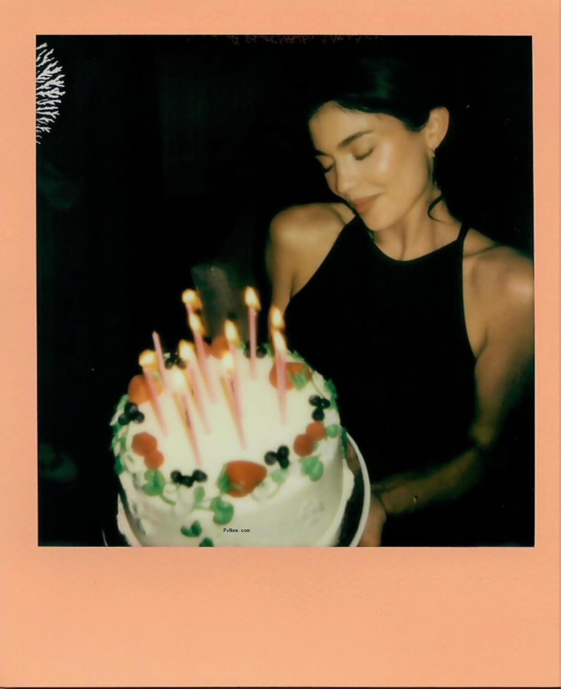 kylie jenner looks at a birthday cake