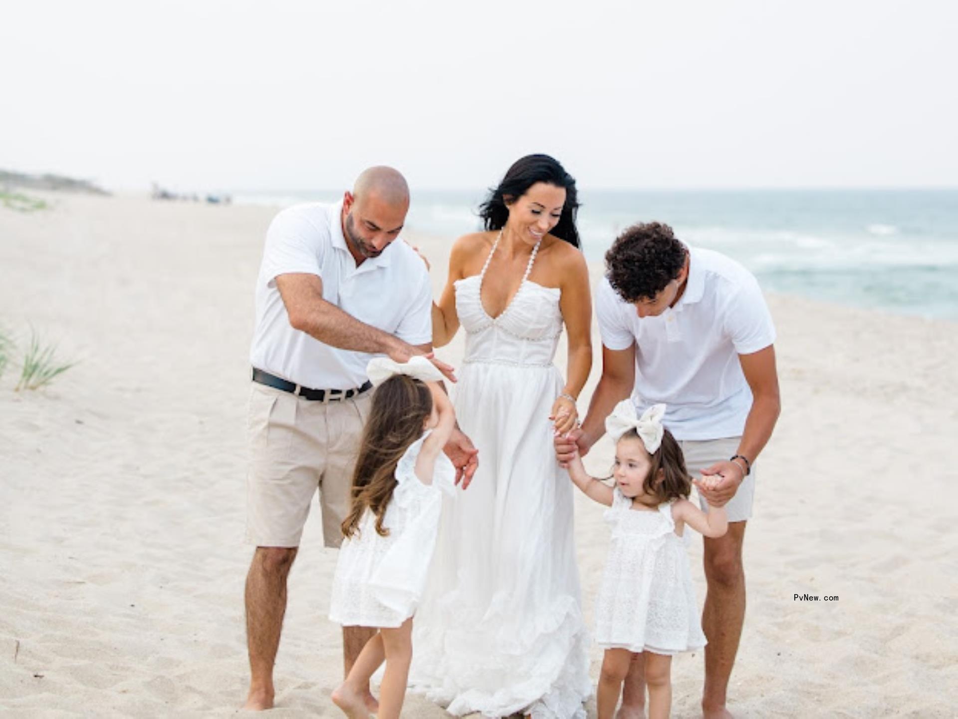 John and Rachel Fuda posing on the beach with their kids