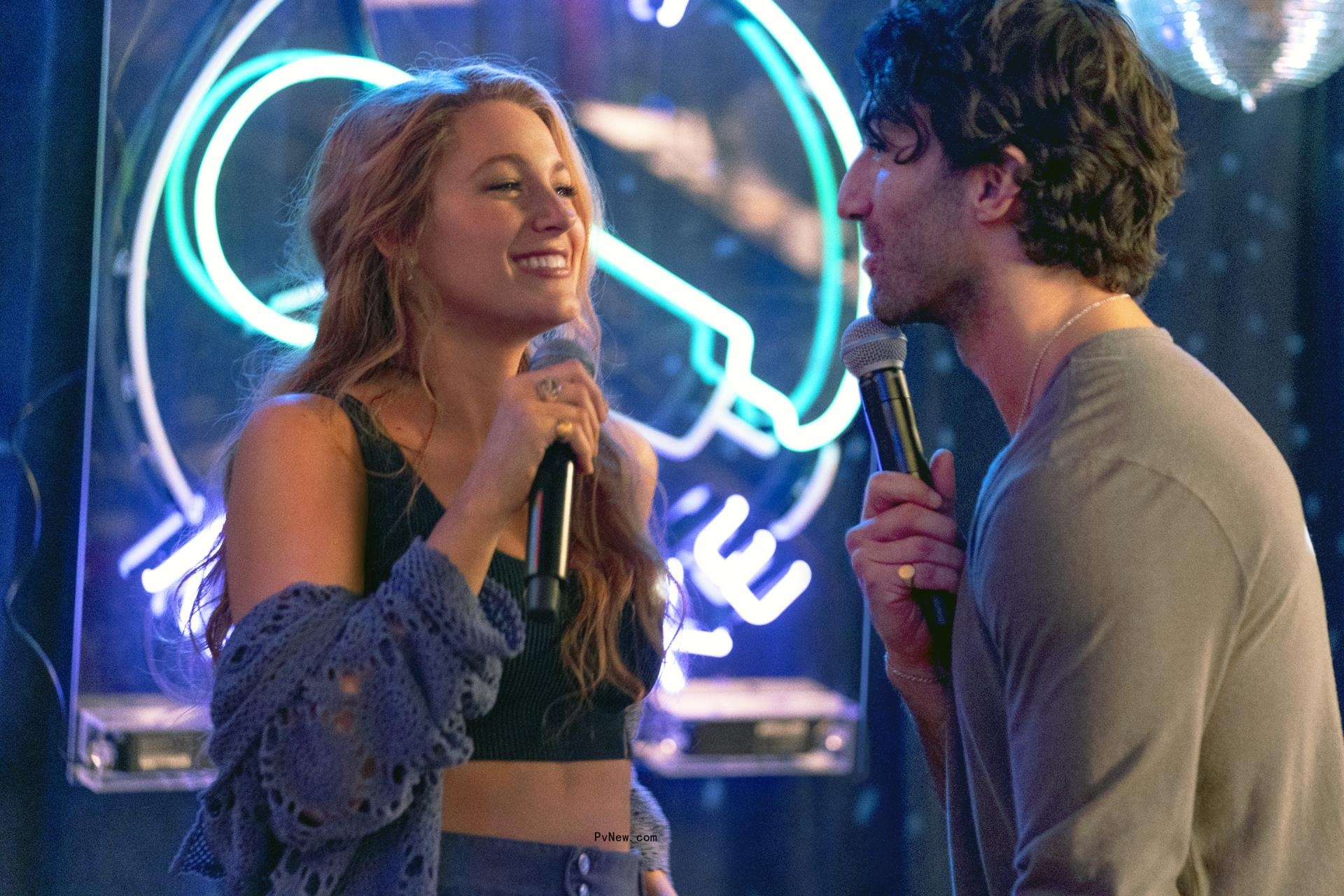 Justin Baldoni and Blake Lively hold microphones.