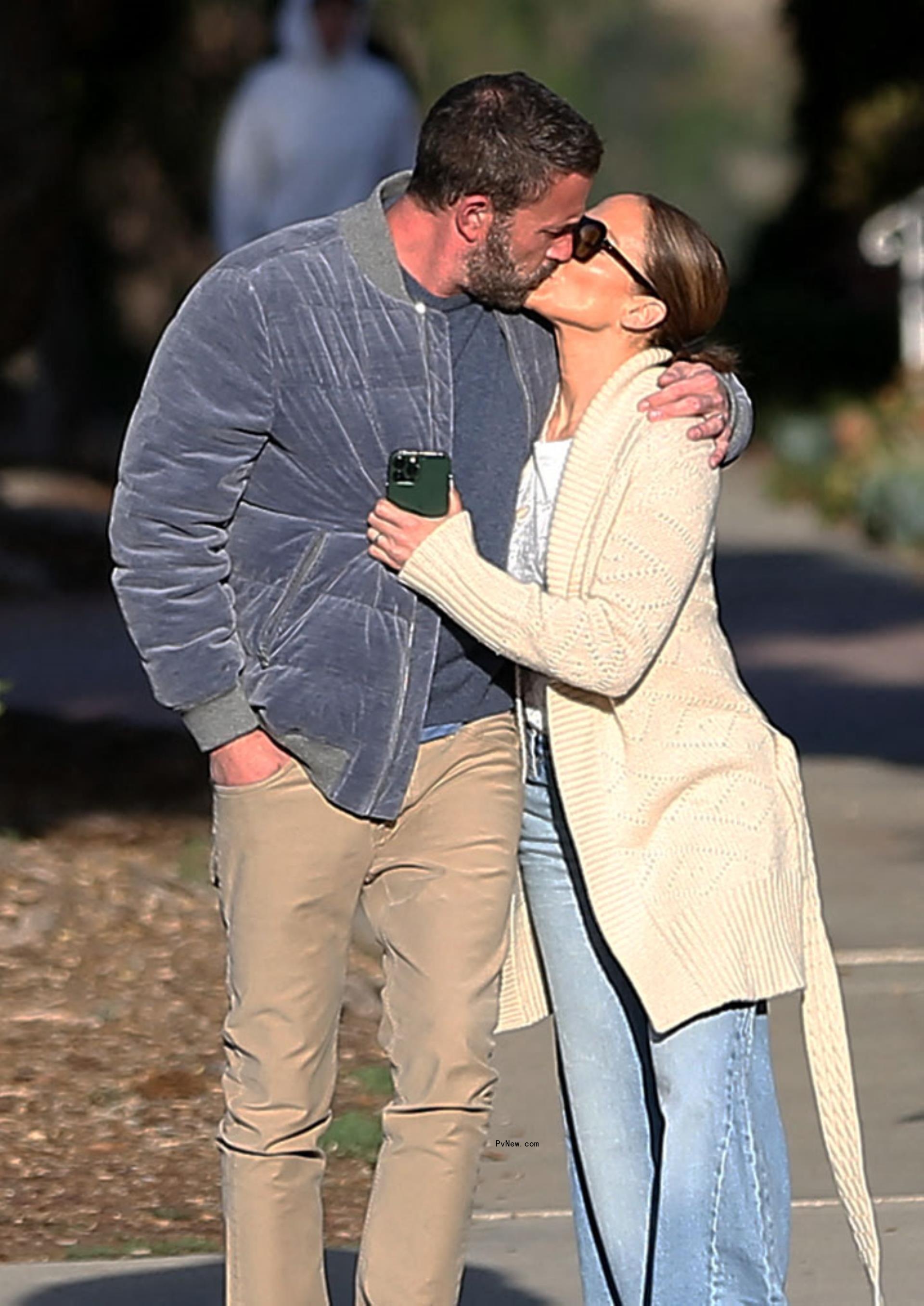 Ben Affleck and Jennifer Lopez share a kiss while out for a morning walk in November.