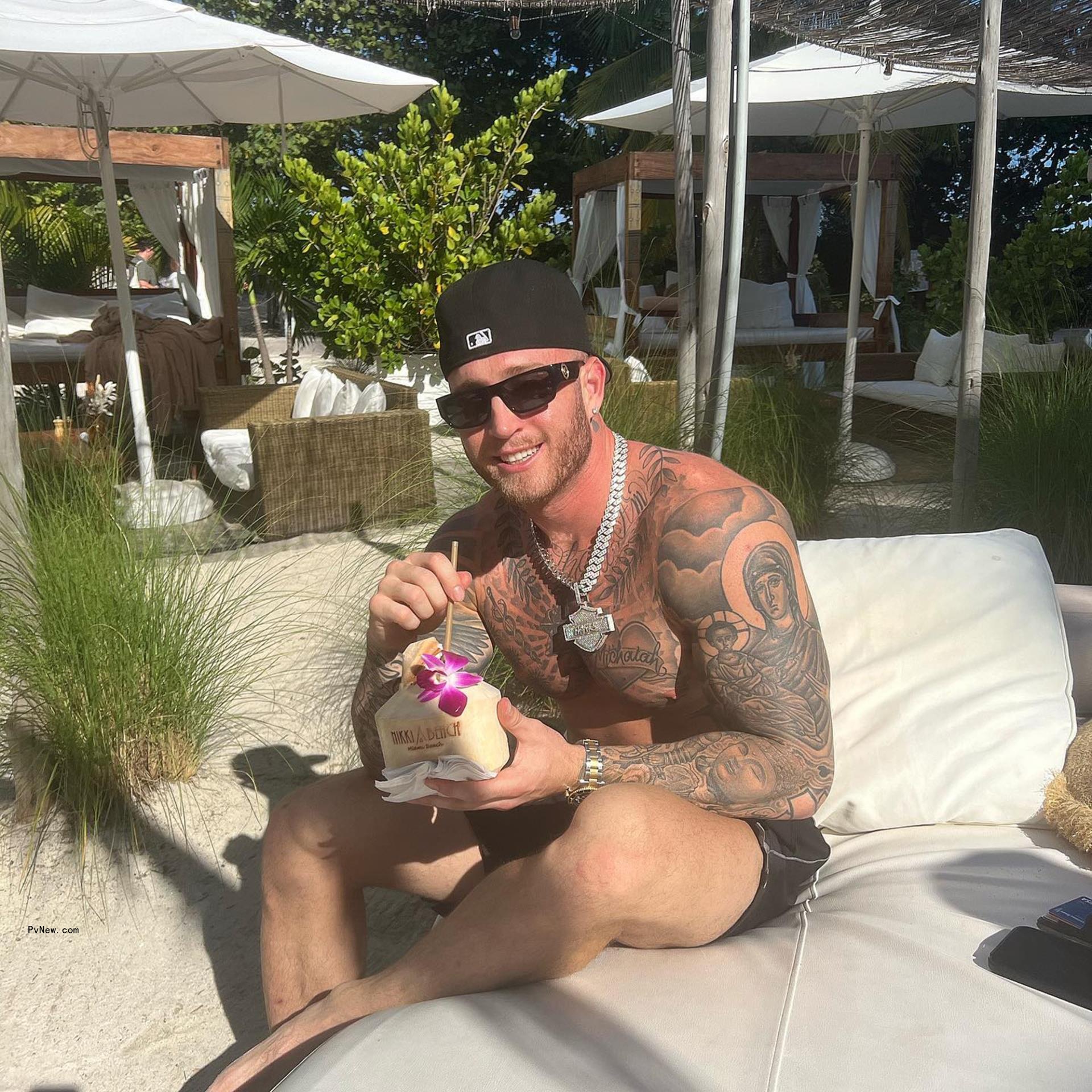 shirtless chet hanks sitting on a pool chaise