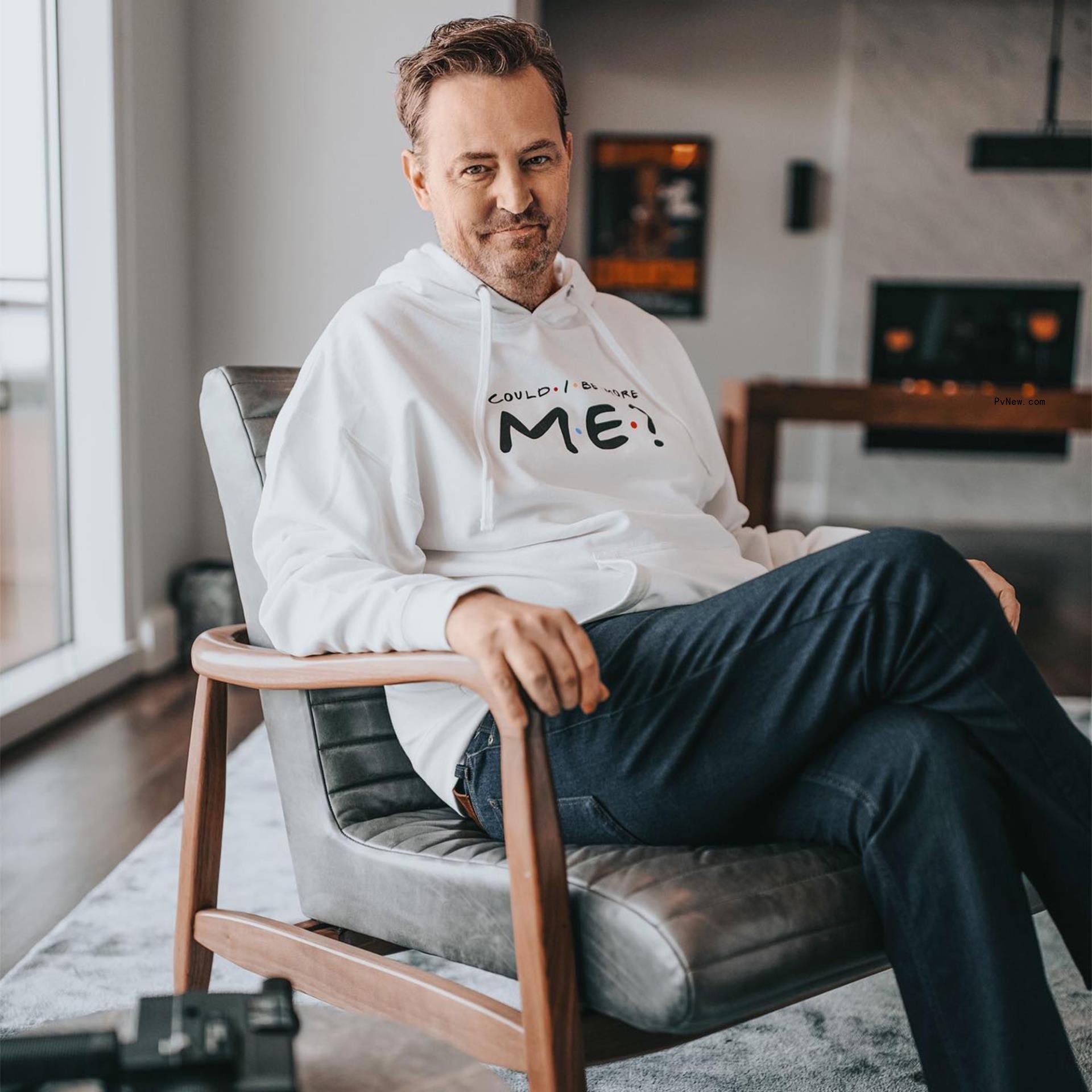 Matthew Perry posing on a chair.