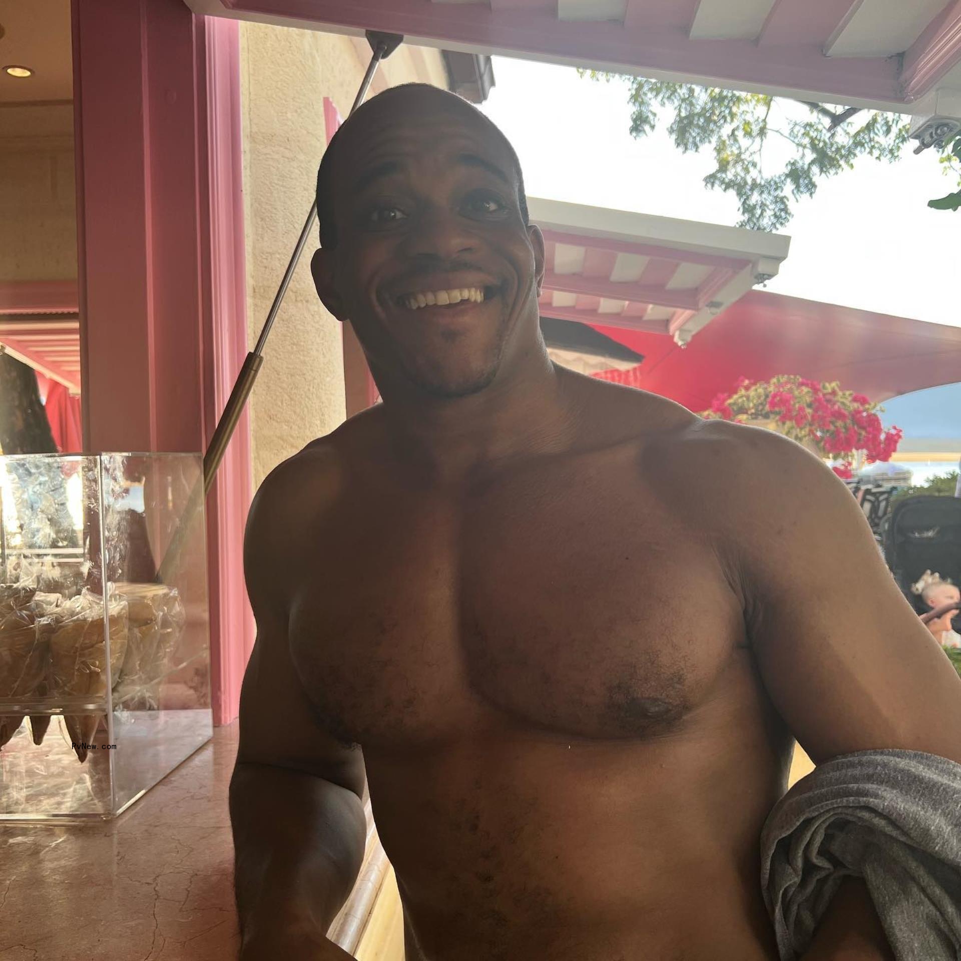 Geoffrey Ogunlesi smiling shirtless. 