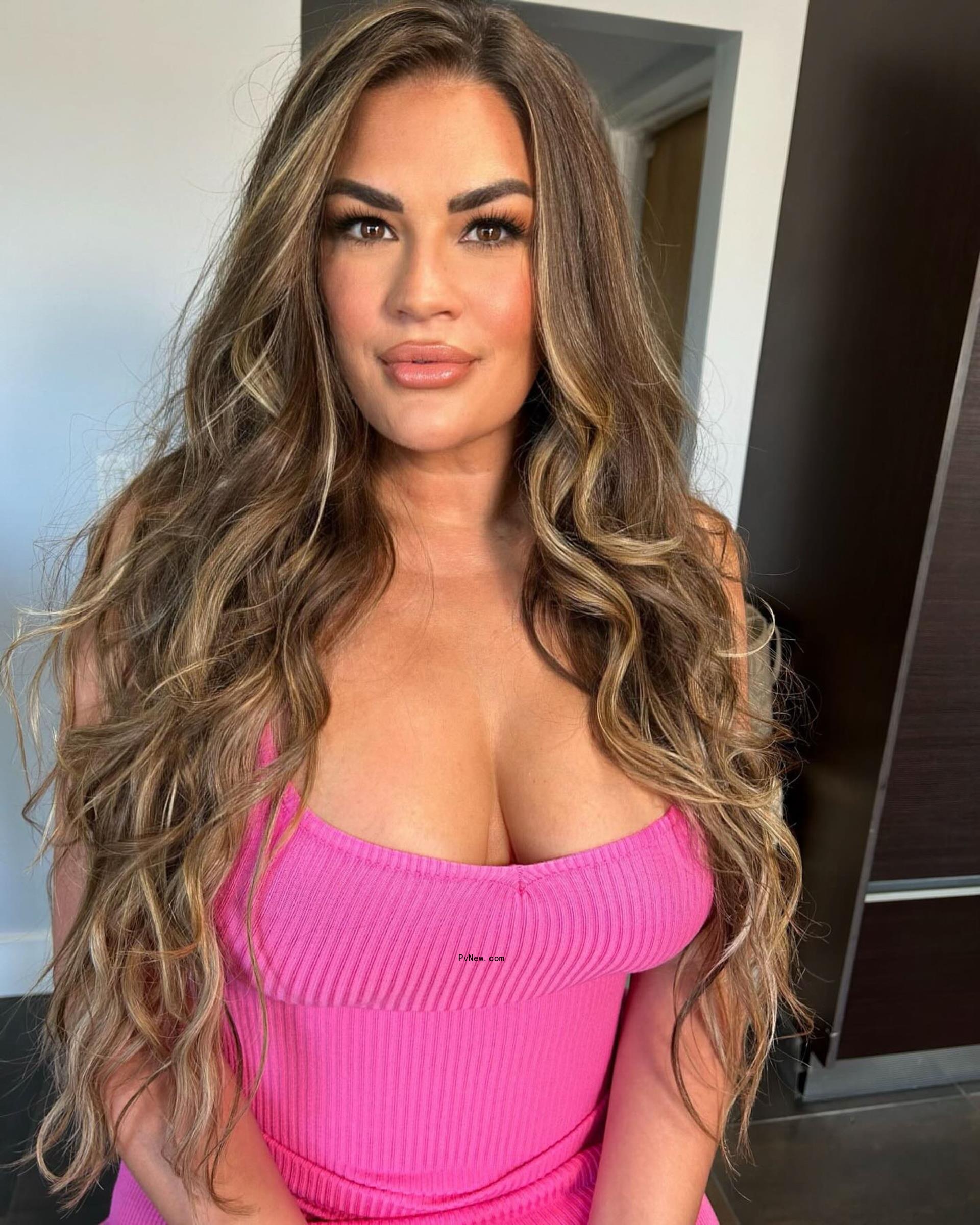 Brittany Cartwright posing in a hot-pink top in August 2024